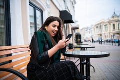 Excited woman reading amazing news on line in a smart phone at the street cafe. royalty free stock photos Excited woman reading amazing news on line in a smart phone at the street cafe. royalty free stock photos