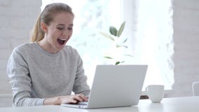 Excited Young Woman Celebrating Success, Working on Laptop stock footage Excited Young Woman Celebrating Success, Working on Laptop stock footage