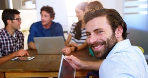 Executivos que discutem sobre a tabuleta e o portátil digitais filme Executivos que discutem sobre a tabuleta e o portátil digitais filme