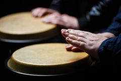 Executores que jogam cilindros de bongos Feche acima da mão do músico que joga cilindros de bongos Cilindro Mãos de um músico que imagem de stock Executores que jogam cilindros de bongos Feche acima da mão do músico que joga cilindros de bongos Cilindro Mãos de um músico que imagem de stock