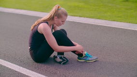 Exhausted woman sitting on asphalt road after running marathon stock footage Exhausted woman sitting on asphalt road after running marathon stock footage