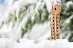 Exibição do termômetro que congela a temperatura fria na neve imagem de stock royalty free Exibição do termômetro que congela a temperatura fria na neve imagem de stock royalty free