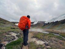 Experienced male hiker hiking alone into the wild admiring geothermal landscape of steaming ground with big, heavy backpack royalty free stock images Experienced male hiker hiking alone into the wild admiring geothermal landscape of steaming ground with big, heavy backpack royalty free stock images
