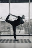 Experienced yoga man doing various poses indoors, panoramic city view at background stock photo Experienced yoga man doing various poses indoors, panoramic city view at background stock photo