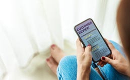 Experiencia del cliente y concepto en línea del comentario Sentada femenina adentro fotografía de archivo libre de regalías Experiencia del cliente y concepto en línea del comentario Sentada femenina adentro fotografía de archivo libre de regalías