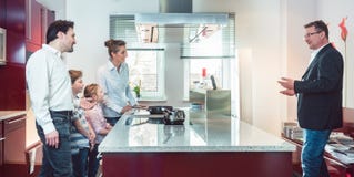 Expert explaining new kitchen to family looking for one stock photography Expert explaining new kitchen to family looking for one stock photography