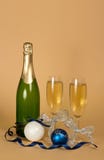 Exponeringsglas av champagne dekorerade med silverbandet, leksaker för nytt år och slingrande, på beiga arkivbilder Exponeringsglas av champagne dekorerade med silverbandet, leksaker för nytt år och slingrande, på beiga arkivbilder