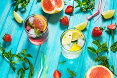 Exponeringsglas av kall coctail för alkohol dekorerade med is, frukt och mintkaramellen som blir på den wood tabellen Ny fruktsaf royaltyfri bild Exponeringsglas av kall coctail för alkohol dekorerade med is, frukt och mintkaramellen som blir på den wood tabellen Ny fruktsaf royaltyfri bild