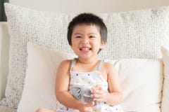 Exponeringsglas för dricksvatten för lycklig liten asiatisk flickahand hållande arkivbilder Exponeringsglas för dricksvatten för lycklig liten asiatisk flickahand hållande arkivbilder