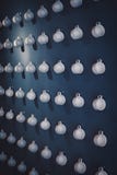 Exposition peu commune des tasses de thé blanches de porcelaine accrochant sur le mur par la poignée image libre de droits Exposition peu commune des tasses de thé blanches de porcelaine accrochant sur le mur par la poignée image libre de droits