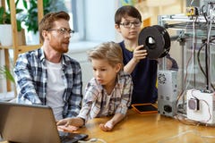 Expressive blonde kid observing laptop screen while his dark-haired friends royalty free stock photo Expressive blonde kid observing laptop screen while his dark-haired friends royalty free stock photo