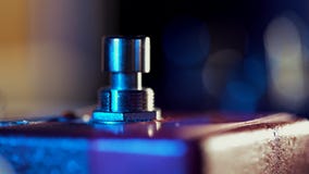 Extremely close up of guitarist foot in sneakers pressing button for effect electro guitar pedal. Red neon light in stock video footage Extremely close up of guitarist foot in sneakers pressing button for effect electro guitar pedal. Red neon light in stock video footage