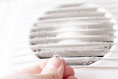 Extremely dirty and dusty white plastic ventilation air grille at home close up and a hand holding dust by fingers, harmful for stock photo Extremely dirty and dusty white plastic ventilation air grille at home close up and a hand holding dust by fingers, harmful for stock photo
