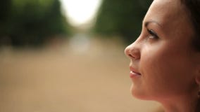 Extremo cercano para arriba de una mujer morena joven Tiro al aire libre del sideface almacen de video Extremo cercano para arriba de una mujer morena joven Tiro al aire libre del sideface almacen de video