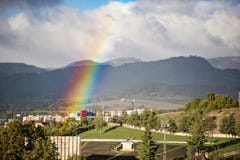 Extrémité d'un arc-en-ciel dans le ciel au-dessus de la ville dans le jour ensoleillé photo libre de droits Extrémité d'un arc-en-ciel dans le ciel au-dessus de la ville dans le jour ensoleillé photo libre de droits