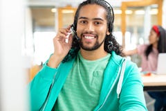 Exécutif masculin de service à la clientèle regardant la caméra et parlant sur le casque dans un bureau moderne image libre de droits Exécutif masculin de service à la clientèle regardant la caméra et parlant sur le casque dans un bureau moderne image libre de droits