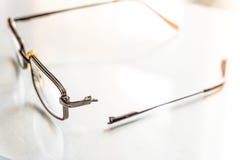 Eyeglasses with a broken handle on a bright background stock image Eyeglasses with a broken handle on a bright background stock image