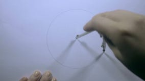 Żeński ręka remis okrąg z dividers Żeński ręka remis okrąg z dividers