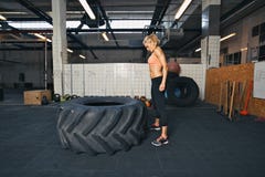 Żeńskiej atlety spełniania opona podrzuca crossfit ćwiczenie fotografia stock Żeńskiej atlety spełniania opona podrzuca crossfit ćwiczenie fotografia stock