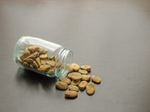 Faba de vicia de f?ves sont vers?es d'un pot en verre sur la surface en bois brune image stock Faba de vicia de f?ves sont vers?es d'un pot en verre sur la surface en bois brune image stock
