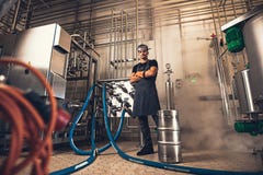 Fabbricante di birra sicuro in grembiule alla fabbrica della fabbrica di birra fotografia stock libera da diritti Fabbricante di birra sicuro in grembiule alla fabbrica della fabbrica di birra fotografia stock libera da diritti
