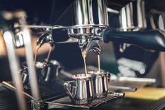 Fabricación del café en una máquina profesional del café en la cafetería en las tazas del hierro foto de archivo Fabricación del café en una máquina profesional del café en la cafetería en las tazas del hierro foto de archivo