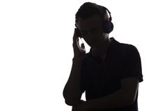 Face profile silhouette of music lover teenager listening to favorite song in headphones , handsome young man on white stock image Face profile silhouette of music lover teenager listening to favorite song in headphones , handsome young man on white stock image