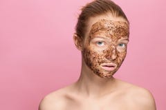 Face Skin Scrub. Portrait Of Smiling Female Model Applying Natural Coffee Mask, Face Scrub On Facial Skin. Closeup Royalty Free Stock Images
