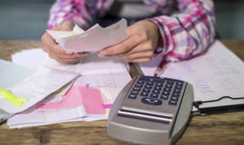 Faceless anonymous woman hands working with bank paperwork bills and financial documents calculating monthly expenses and debt wit Royalty Free Stock Photography Faceless anonymous woman hands working with bank paperwork bills and financial documents calculating monthly expenses and debt wit Royalty Free Stock Photography