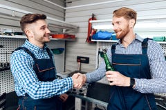 Fadern och sonen arbetar på den auto servicen Två mekaniker arbetar med detaljerna av bilen royaltyfri fotografi Fadern och sonen arbetar på den auto servicen Två mekaniker arbetar med detaljerna av bilen royaltyfri fotografi