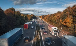 Fahrzeuge in der Bewegung auf beschäftigter ländlicher Autobahn lizenzfreies stockbild Fahrzeuge in der Bewegung auf beschäftigter ländlicher Autobahn lizenzfreies stockbild