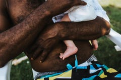 Fait violence d'un père noir portant son bébé garçon de métis image stock Fait violence d'un père noir portant son bébé garçon de métis image stock