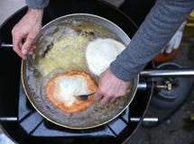 Faites cuire les mains pendant la préparation des beignets en huile chaude photos libres de droits Faites cuire les mains pendant la préparation des beignets en huile chaude photos libres de droits