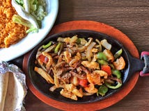 Fajitas mexicanos da galinha em uma placa quente imagem de stock royalty free Fajitas mexicanos da galinha em uma placa quente imagem de stock royalty free