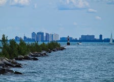 Fala jezioro michigan nawadniają trzaska przeciw łamanie ścianie gdy łodzie podróżują obok z linią horyzontu behind Chicago zdjęcie stock Fala jezioro michigan nawadniają trzaska przeciw łamanie ścianie gdy łodzie podróżują obok z linią horyzontu behind Chicago zdjęcie stock