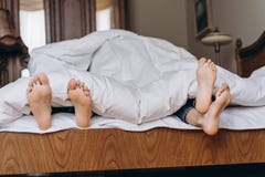 Fam?lia feliz que esconde sob uma cobertura e que joga junto na cama Pais que passam o tempo livre com seu filho fotografia de stock Fam?lia feliz que esconde sob uma cobertura e que joga junto na cama Pais que passam o tempo livre com seu filho fotografia de stock