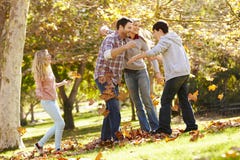Famiglia che getta Autumn Leaves In The Air Immagini Stock Famiglia che getta Autumn Leaves In The Air Immagini Stock