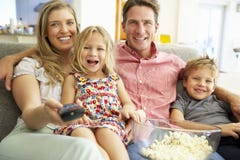 Famiglia che si rilassa su Sofa Watching Television Together Fotografia Stock Famiglia che si rilassa su Sofa Watching Television Together Fotografia Stock