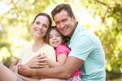 Famiglia che si siede sull'albero in sosta fotografia stock Famiglia che si siede sull'albero in sosta fotografia stock