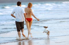 Famiglia con il cane alla spiaggia fotografia stock Famiglia con il cane alla spiaggia fotografia stock