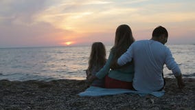 Famiglia con la piccola figlia che si siede vicino al mare Famiglia con la piccola figlia che si siede vicino al mare