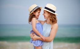 Famiglia felice alla spiaggia abbraccio della figlia del bambino e della madre in mare fotografia stock libera da diritti Famiglia felice alla spiaggia abbraccio della figlia del bambino e della madre in mare fotografia stock libera da diritti