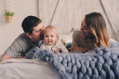 Famiglia felice che gioca a casa sul letto Bloccaggio di stile di vita della madre, del padre e del bambino immagini stock Famiglia felice che gioca a casa sul letto Bloccaggio di stile di vita della madre, del padre e del bambino immagini stock