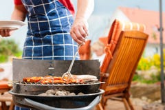 Famiglia felice che ha un barbecue immagine stock libera da diritti Famiglia felice che ha un barbecue immagine stock libera da diritti