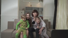 Famiglia felice che si pianta per la squadra di football americano che si siede sullo strato La mamma ed il figlio schiaffeggiano archivi video Famiglia felice che si pianta per la squadra di football americano che si siede sullo strato La mamma ed il figlio schiaffeggiano archivi video