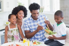 Famiglia felice che si siede insieme alla cena fotografia stock Famiglia felice che si siede insieme alla cena fotografia stock