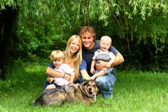 Famiglia felice che si siede sotto Willow Tree immagini stock Famiglia felice che si siede sotto Willow Tree immagini stock