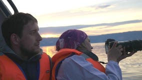 Famiglia felice in vacanza che gode di un giro della barca giù il lago durante il tramonto Il viaggiatore castana femminile prend stock footage Famiglia felice in vacanza che gode di un giro della barca giù il lago durante il tramonto Il viaggiatore castana femminile prend stock footage