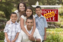 Famiglia ispana davanti al segno venduto di Real Estate fotografia stock Famiglia ispana davanti al segno venduto di Real Estate fotografia stock