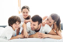 Famiglia sorridente a letto fotografia stock libera da diritti Famiglia sorridente a letto fotografia stock libera da diritti
